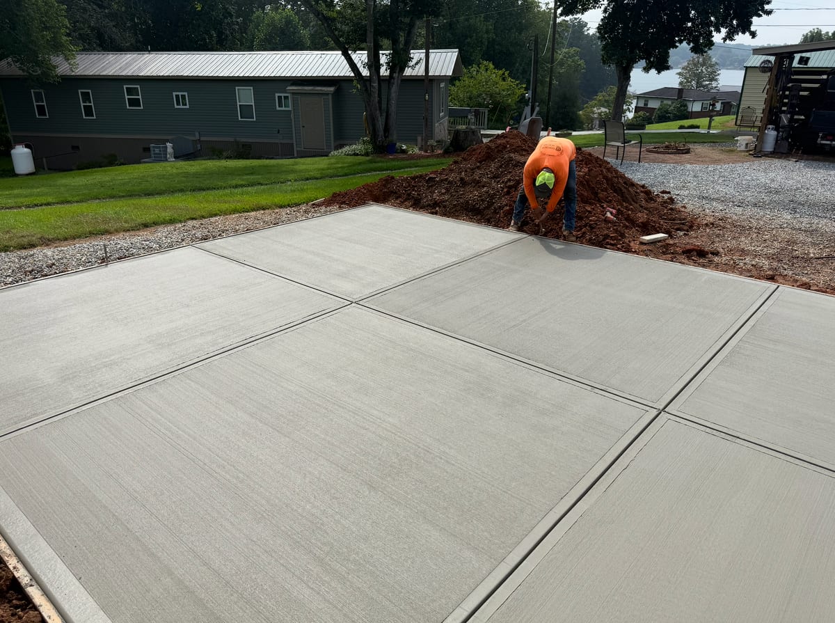 After photo of a finished concrete installation in Charlotte, NC (Mecklenburg County) by Local Driveway Co — broom-finish surface, sawn control joints, full-depth replacement with 4000 PSI commercial mix and double-mat structural rebar, pay-on-completion.