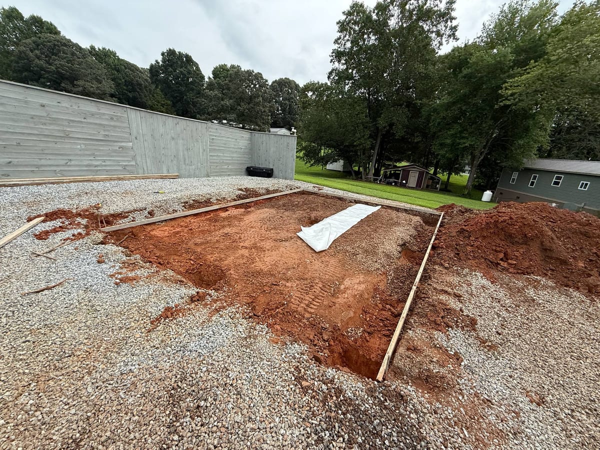 Before photo of a concrete restoration job in Charlotte, NC (Mecklenburg County) by Local Driveway Co — failed slab, surface spalling, and structural cracking documented prior to full demolition and replacement with 4000 PSI mix and #4 rebar.